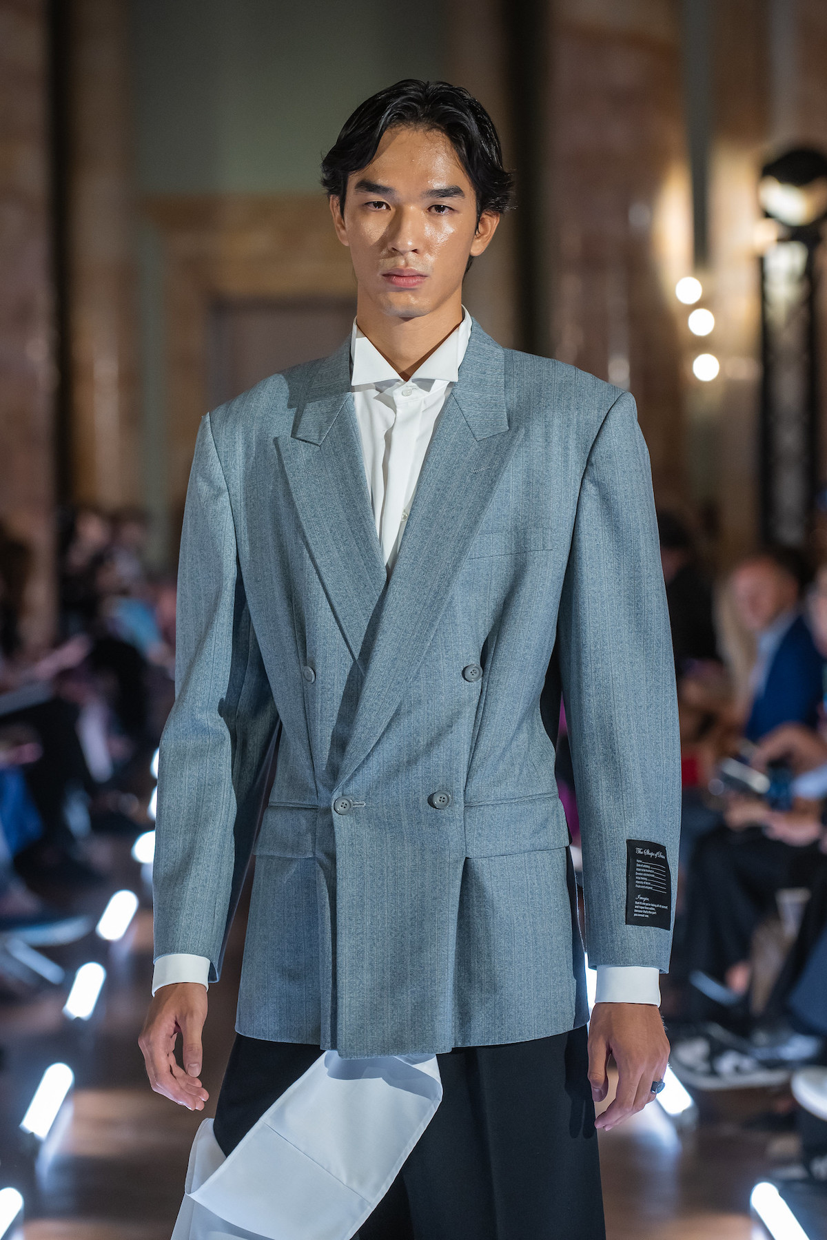 East Bound Roma – польський показ мод у Римі: модель у сірому костюмі оверсайз з білою сорочкою демонструє мінімалістичний геометричний силует.