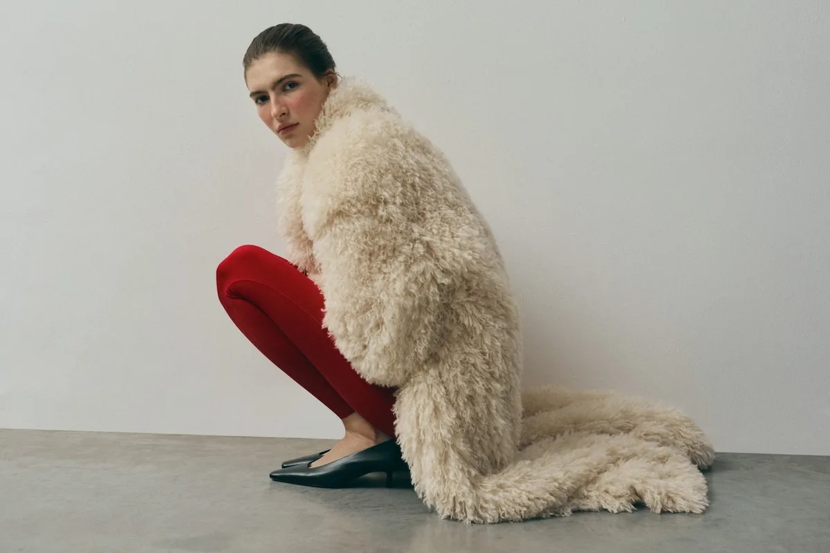 Кампанія бренду L37 – модель у білій шубі та червоних легінсах присіла, дивлячись у камеру.