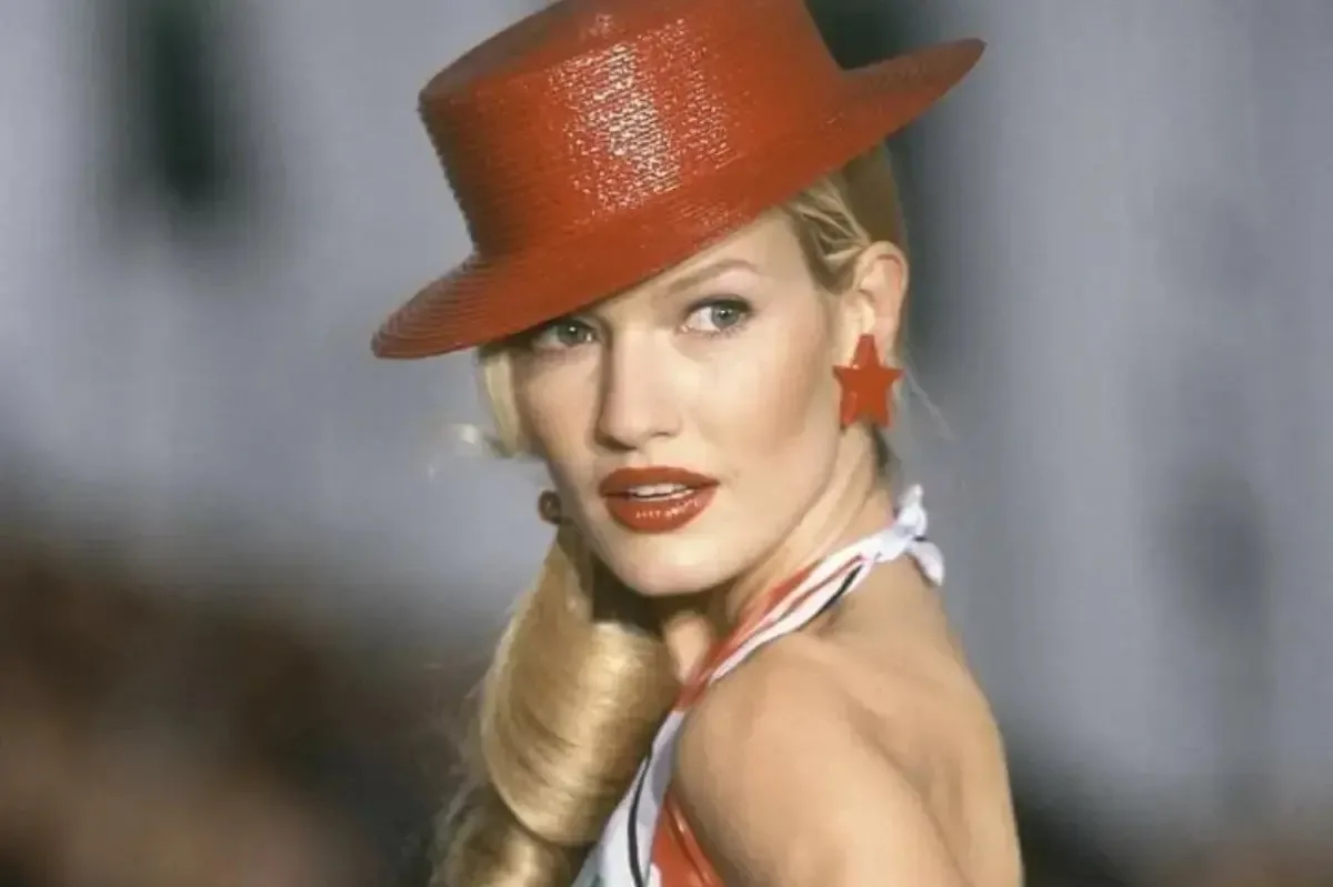 Хто така Карен Малдер? На фото: Карен Малдер на подіумі в 1990-х роках, у червоному капелюсі та сережках із зірками, одна з ікон епохи супермоделей.