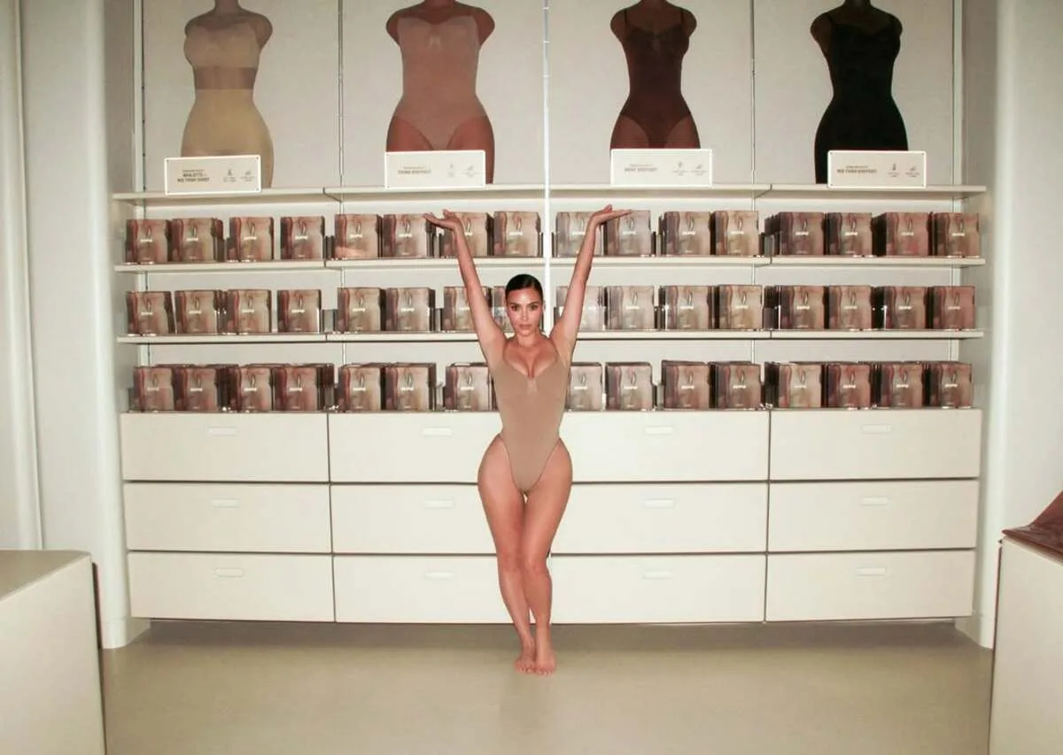 Рейтинг 50 найважливіших жінок у бізнесі 2026 року за версією CNCB. Жінка стоїть у виставковому залі бренду коригуючої білизни в бежевому боді на тлі полиць із упакованими товарами та манекенів, на яких демонструються різні відтінки білизни.