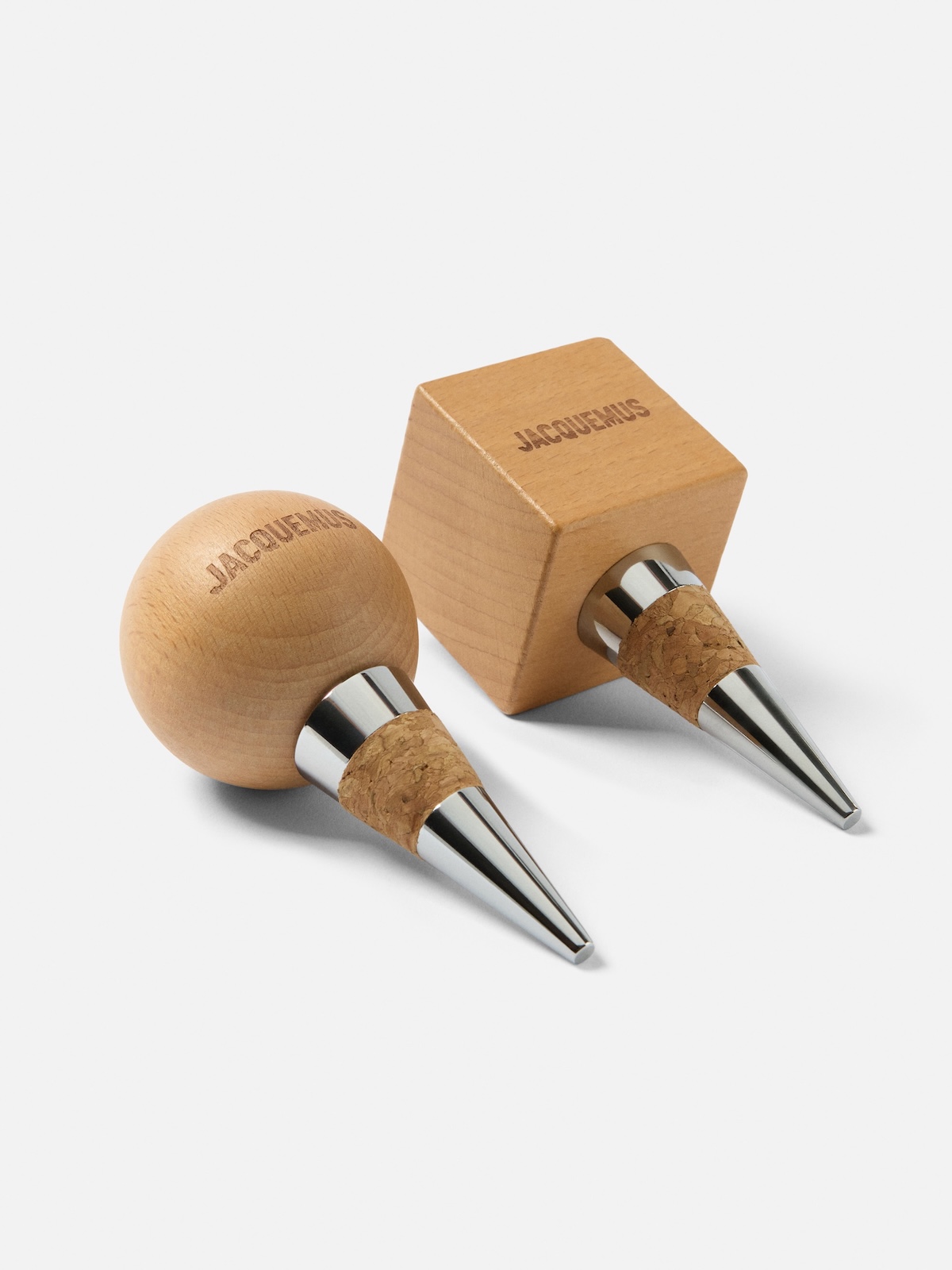 Дві металеві та дерев'яні винні пробки Jacquemus з гравірованим логотипом.