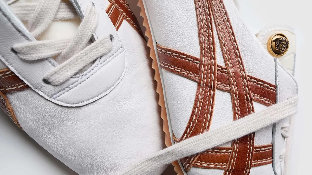 Ці білі кросівки Onitsuka Tiger x Versace мають коричневі ремінці та класичну шнурівку. Видимі деталі ручної роботи та текстурований шкіряний верх надають взуттю преміального, ручного вигляду.