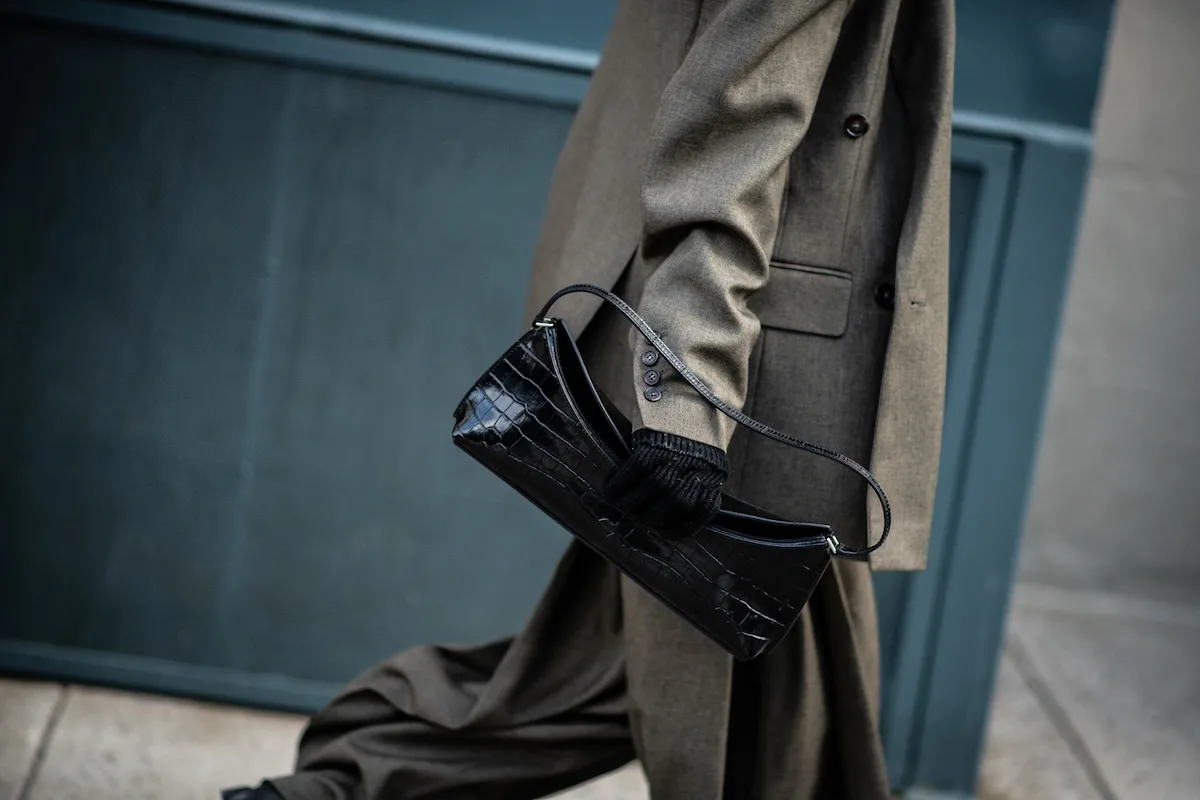 Деталь стилю – елегантна сумочка та класичне пальто в приглушених кольорах підкреслюють позачасовий вуличний стиль. У майбутньому навіть такі невеликі онлайн-покупки можуть стати дорожчими через новий збір за обробку, запроваджений Європейським Союзом.