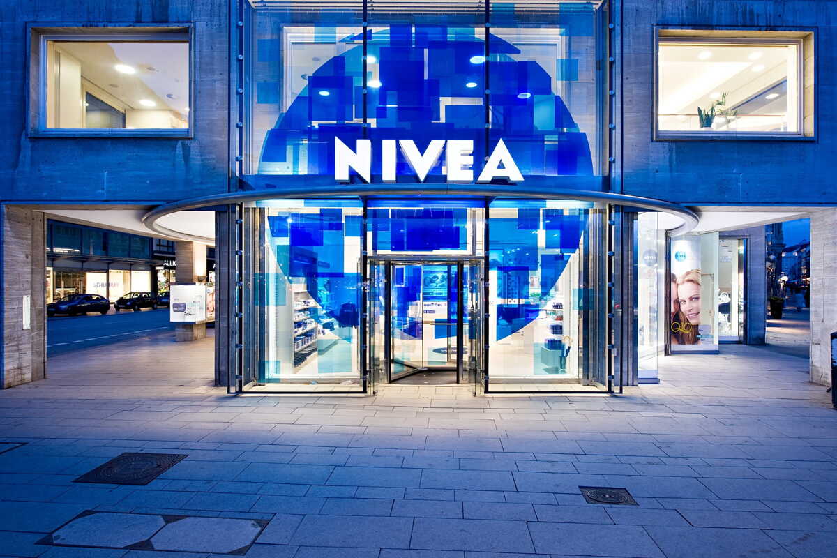 Сучасний вхід до магазину Nivea з його характерним синім логотипом та скляним фасадом. На фото зображено світовий косметичний бренд, який потрапив під пильну увагу Управління з питань конкуренції та захисту прав споживачів (UOKiK) через затримки платежів підрядникам.