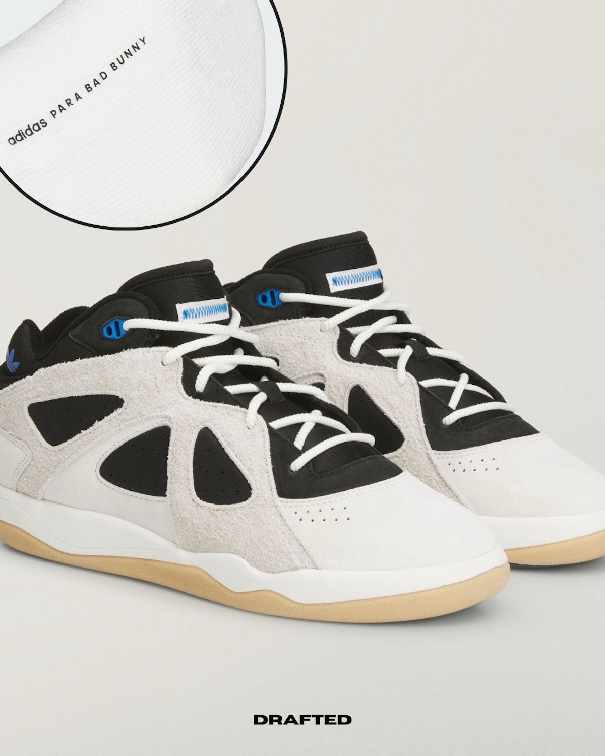 Пара adidas x Bad Bunny, якщо дивитися спереду під кутом, має замшеві вставки, чорну основу, білі шнурки та гумову підошву. Видно.