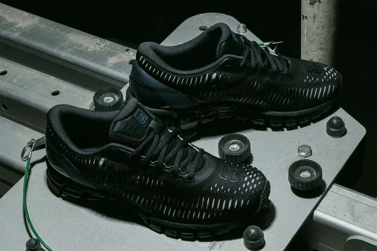 Весняна колаборація кросівок 2026 року. Чорні кросівки з технічним перфорованим дизайном від колаборації C.P. Company, розташовані на промисловій конструкції з металевими елементами. Ця весняна колаборація 2026 року підкреслює сирий, функціональний характер та черпає натхнення зі світу технологій та утилітарного стилю.