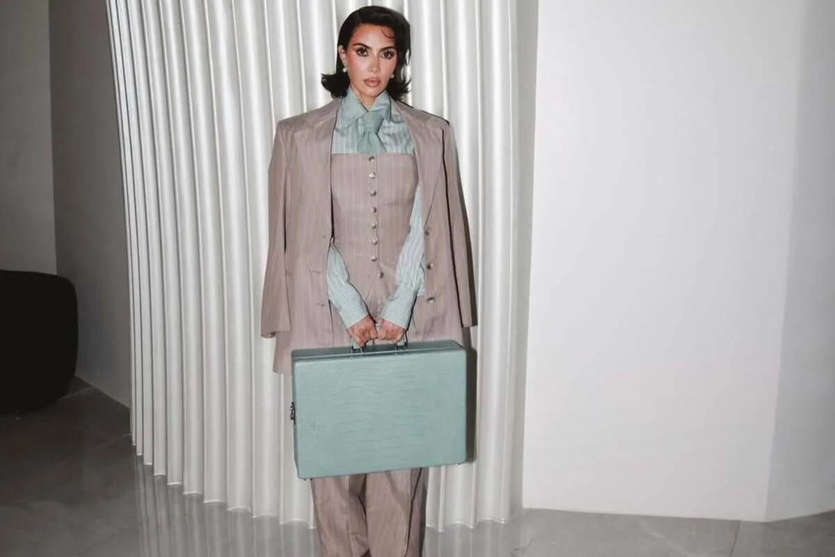 Аукціон Кім Кардаш'ян. Жінка зображена в елегантному діловому вбранні з портфелем, натхненному естетикою телесеріалу.