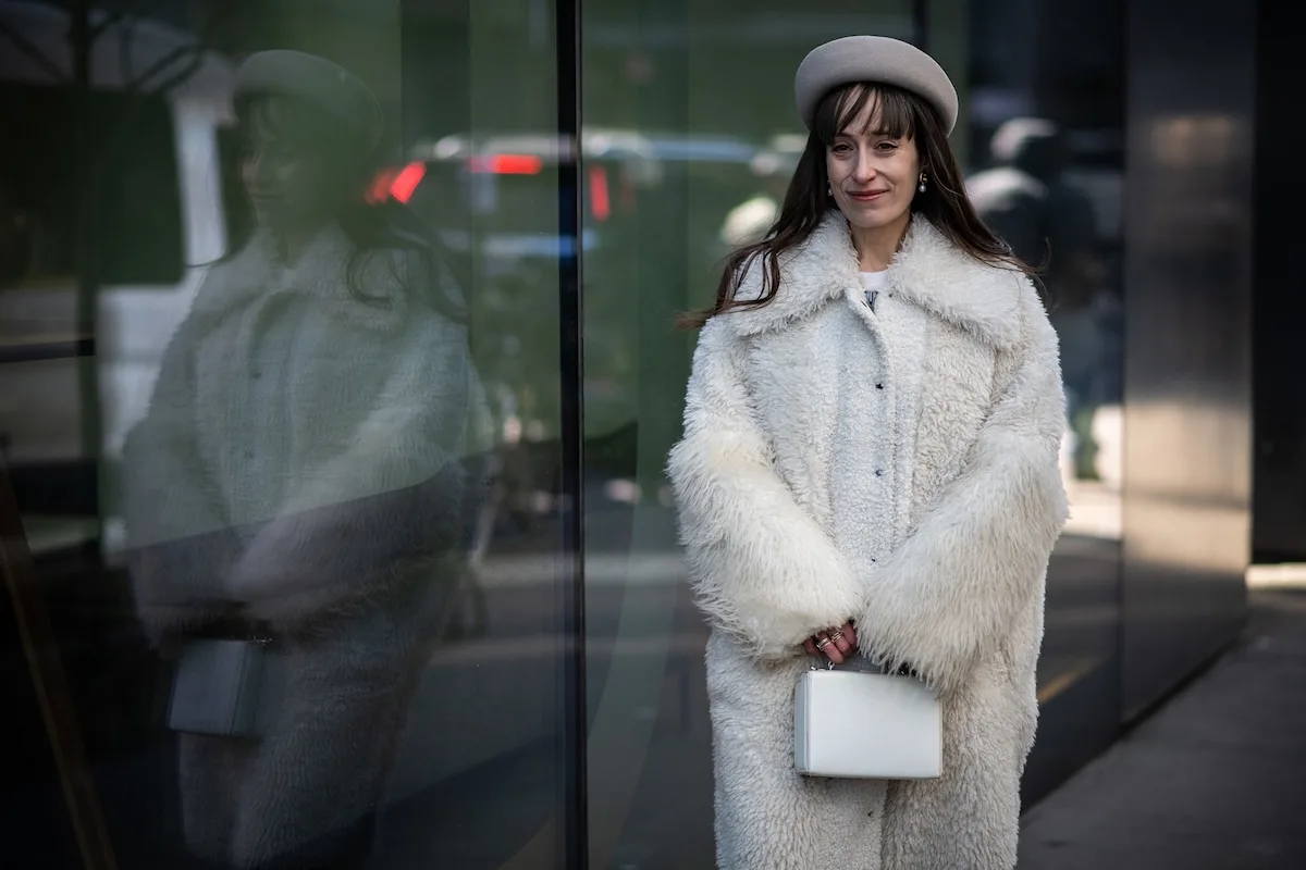 Стильна жінка у легкому пальто на тлі міста – графіка, що супроводжує текст про нове національне свято в Польщі. 12 квітня – дата, встановлена як День інвалідів війни.