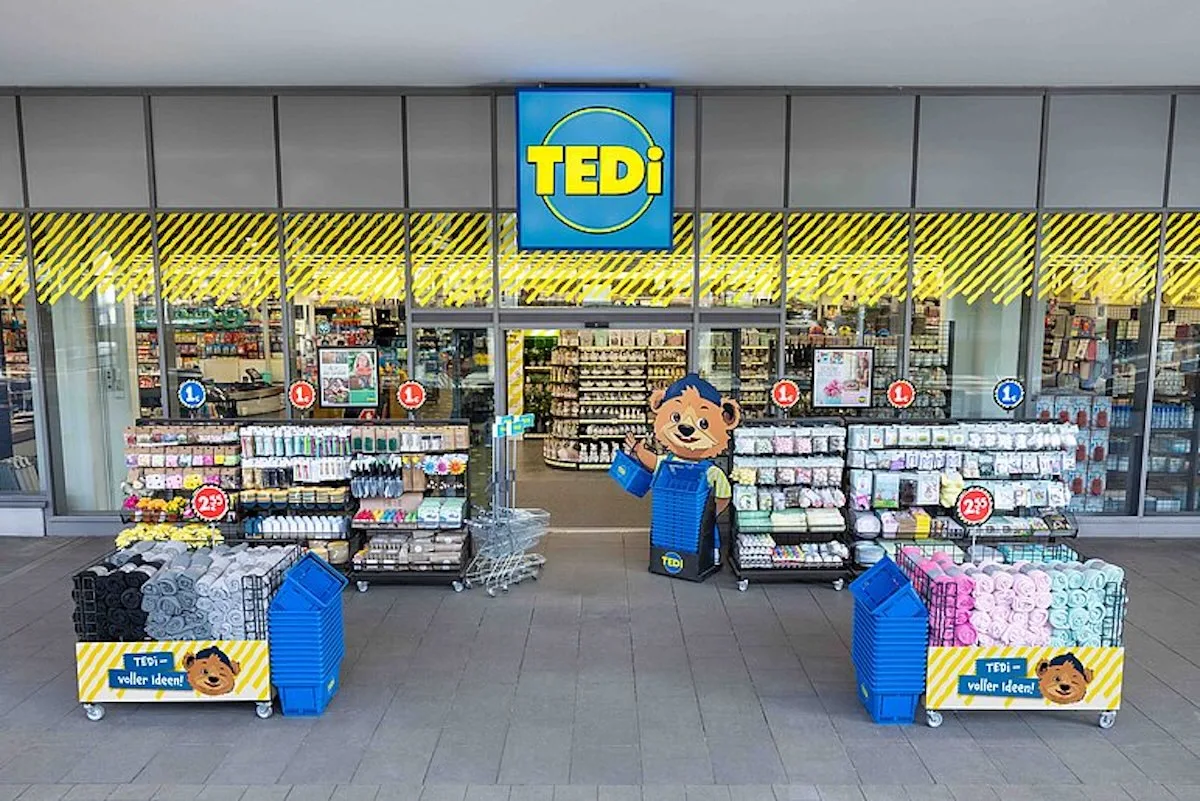 Мережевий магазин TEDi – вхід до дисконтного магазину, що продає товари для дому та декор, з характерним жовто-синім логотипом та вітриною дешевих товарів перед входом.