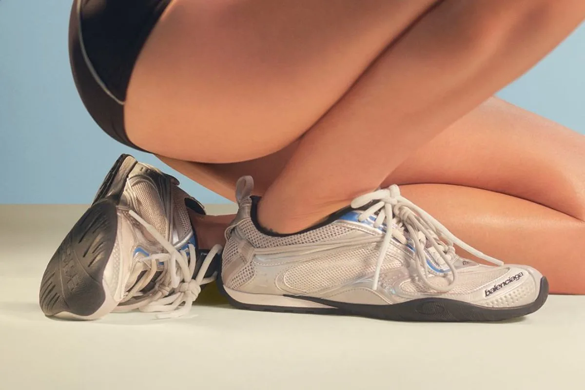 Нові кросівки Balenciaga. Крупний план кросівок Balenciaga зі спортивним, технічним дизайном на легкому, літньому тлі. Модель відповідає новій лінійці продуктів, поєднуючи функціональність з естетикою розкішного вуличного одягу. Зображення ілюструє повернення бренду до кросівок як ключового елементу його стратегії.