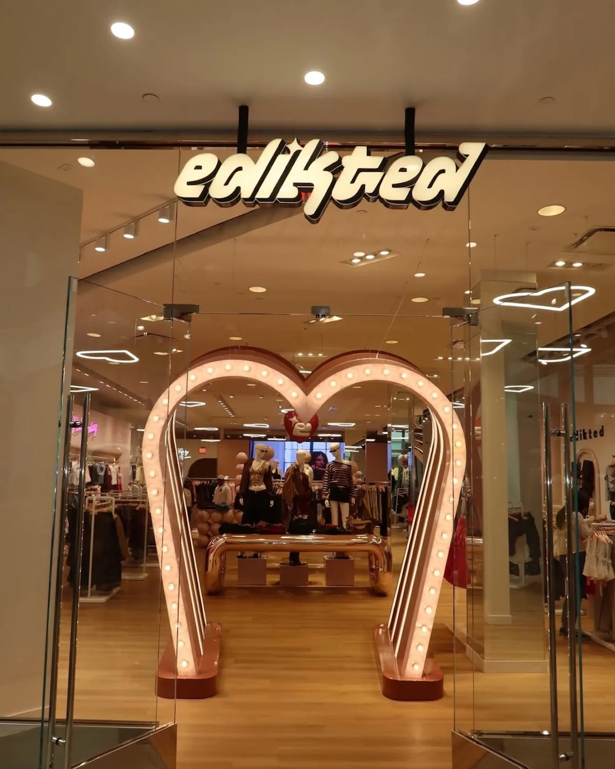 Вхід до магазину Edikted з його характерним логотипом та світловою інсталяцією у формі серця привертає увагу покупців. Це приклад нового етапу розвитку бренду, який розширює свою мережу стаціонарних магазинів по всій Європі.