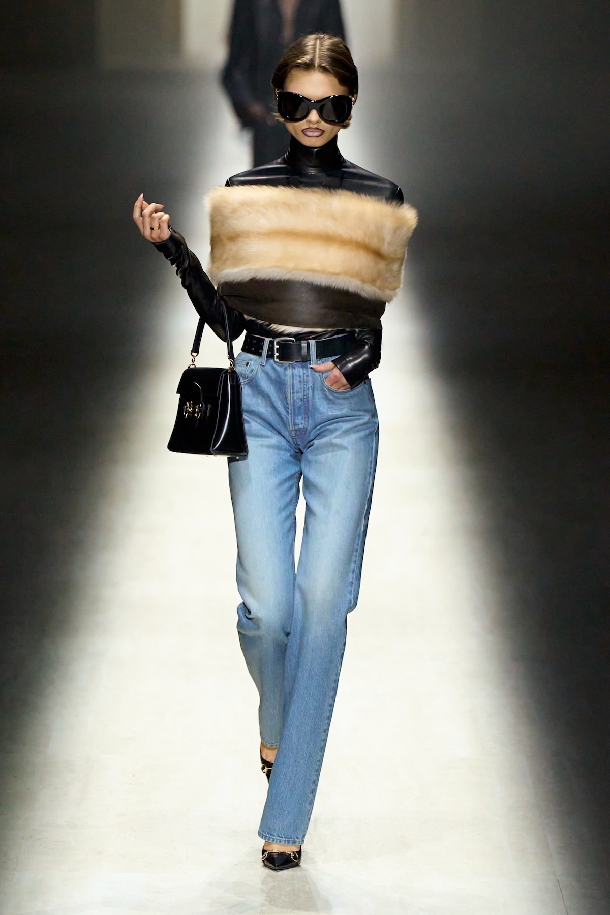 Модель Gucci в сонцезахисних окулярах, хутряному топі та джинсах - показ мод Gucci