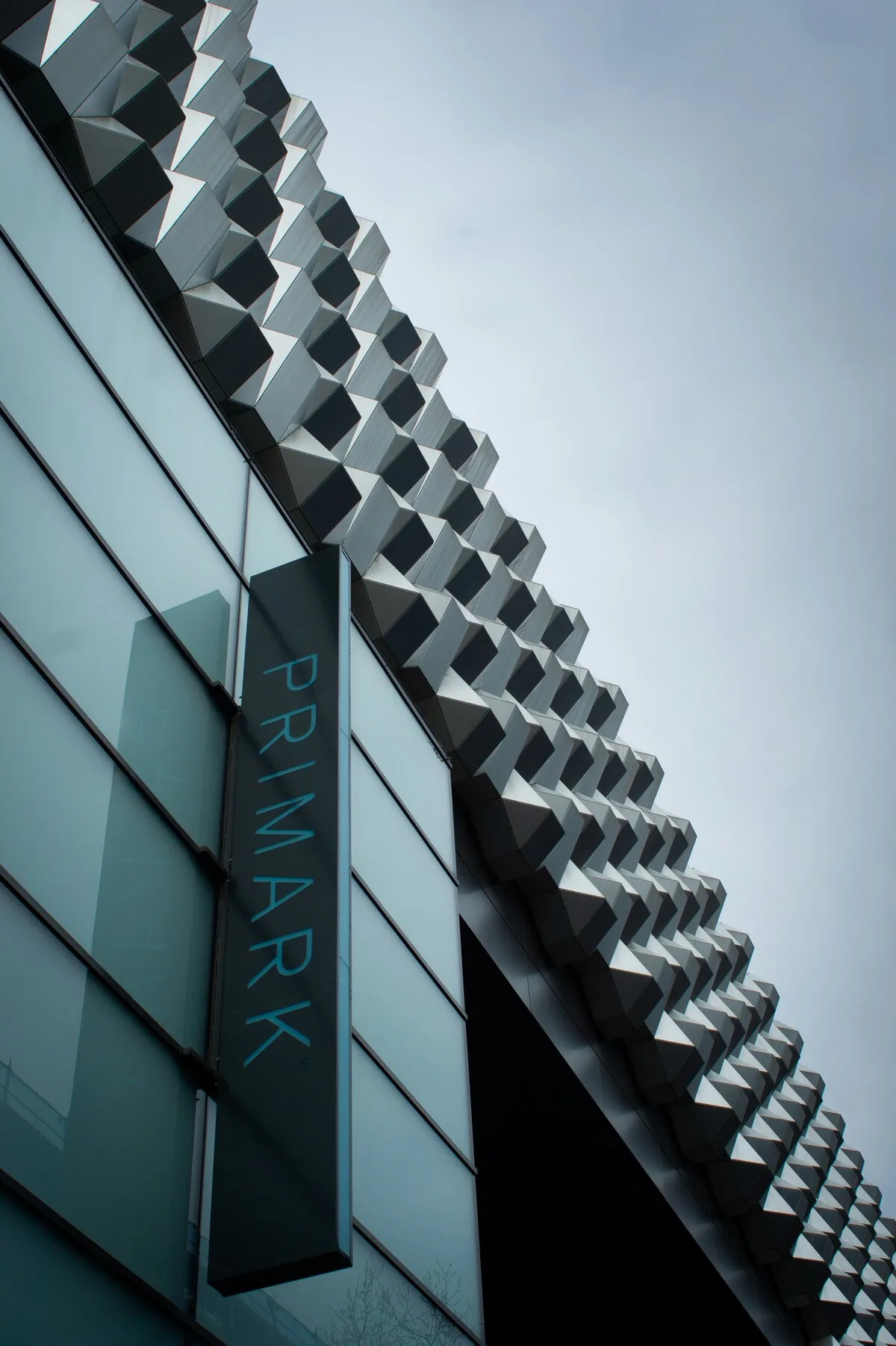 Сучасний фасад магазину Primark вирізняється характерним геометричним візерунком. На будівлі розміщено вертикальний логотип бренду, а загальний дизайн мінімалістичний та урбаністичний.