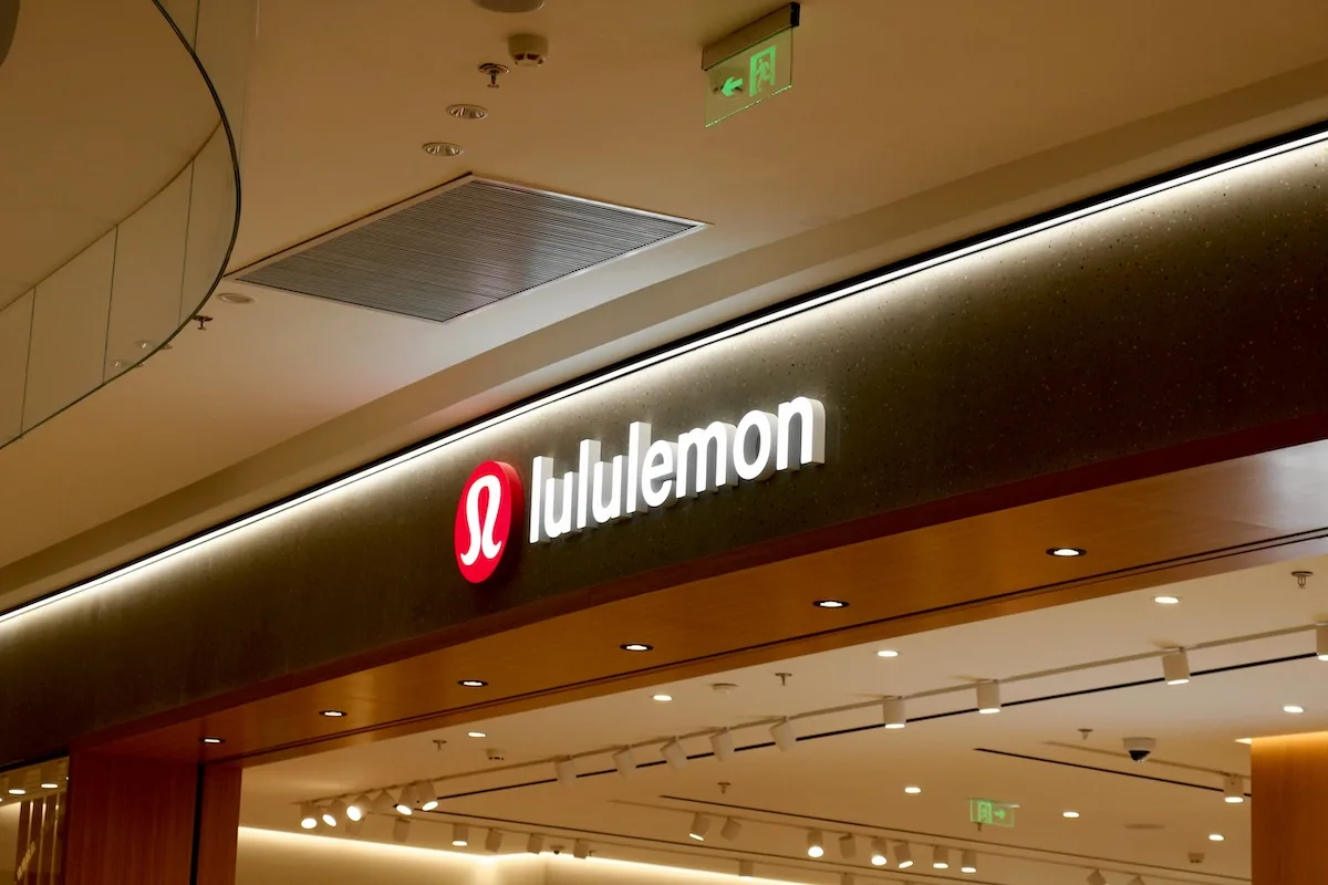 Крупний план логотипу Lululemon над входом до звичайного магазину.