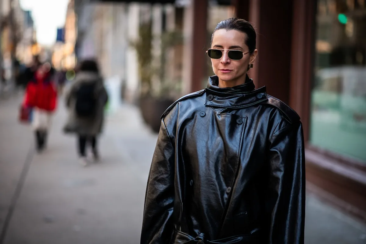 Жінка в чорному пальто йде міською вулицею, перебуваючи на лікарняному (L4) – приклад дозволеної діяльності, що відповідає рекомендаціям лікаря. Нові правила з 2026 року посилюють перевірки ZUS (Установи соціального страхування), які можуть оцінити, чи негативно така діяльність впливає на процес лікування.