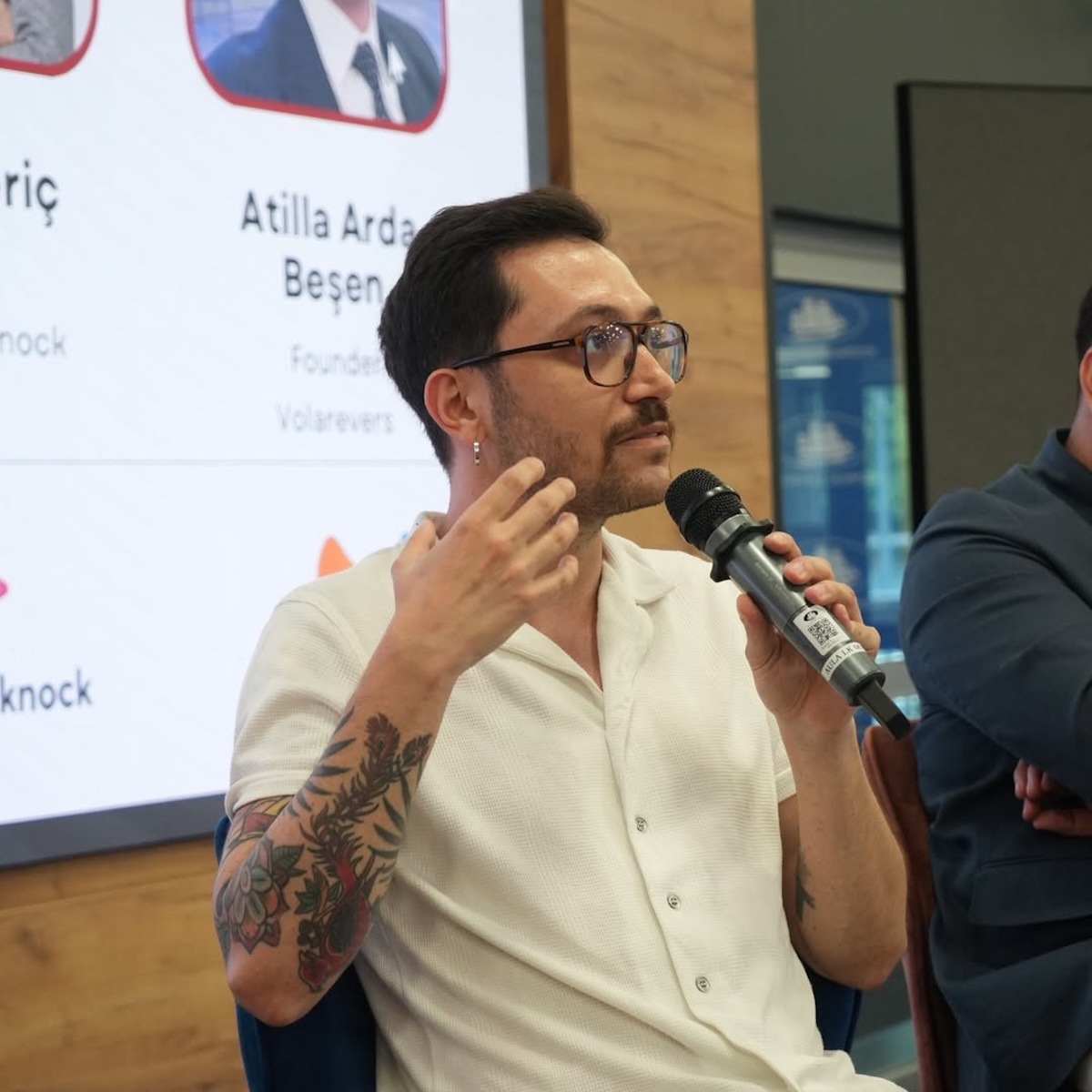 Крупний план спікера стартапу Replenit – чоловік у світлій сорочці та окулярах говорить у мікрофон під час панельної дискусії.