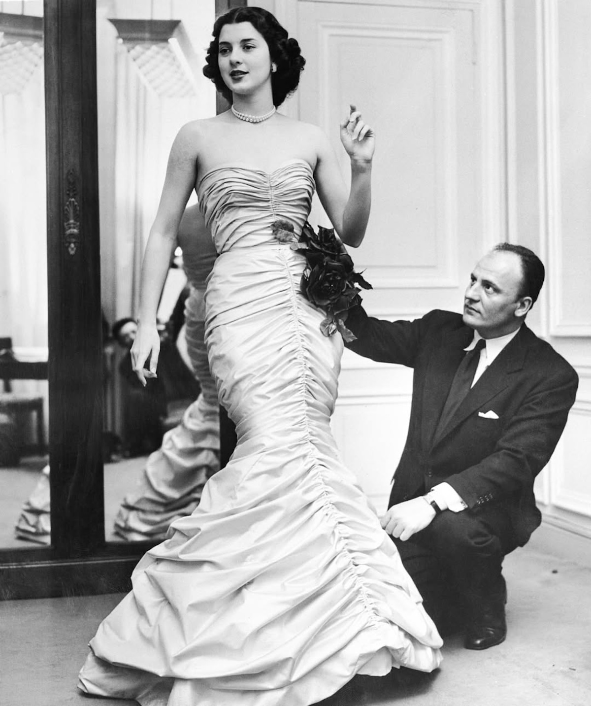 П'єр Бальмен поправляє вечірню сукню на моделі під час примірки одягу від кутюр у своєму паризькому ательє.