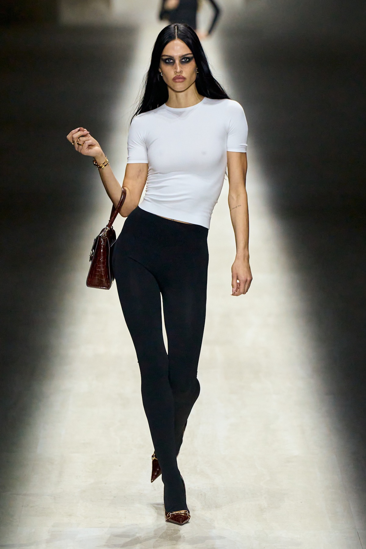 Модель на подіумі Gucci у мінімалістичному топі та чорних легінсах – стиль нової колекції