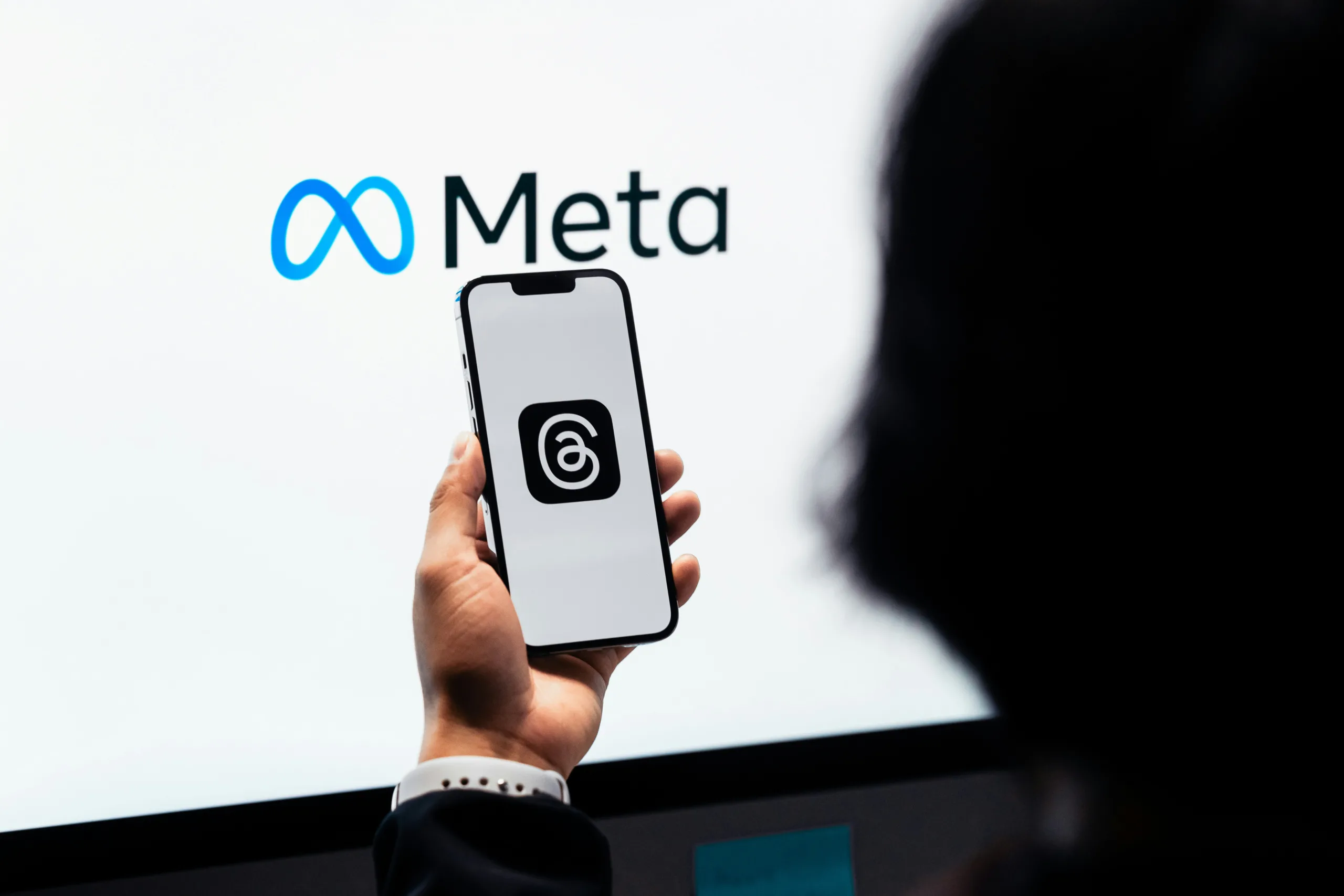 Смартфон із застосунком Threads на тлі логотипу Meta. Компанія Марка Цукерберга проводить масові звільнення та прискорює розробку штучного інтелекту.